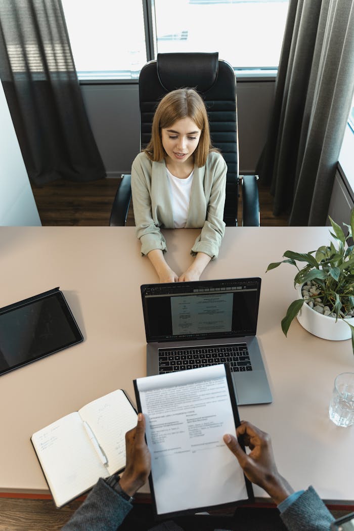 The Art of Drawing Readers In: Your attractive post title goes here High-angle view of a job interview in a modern office setting, capturing professionalism.